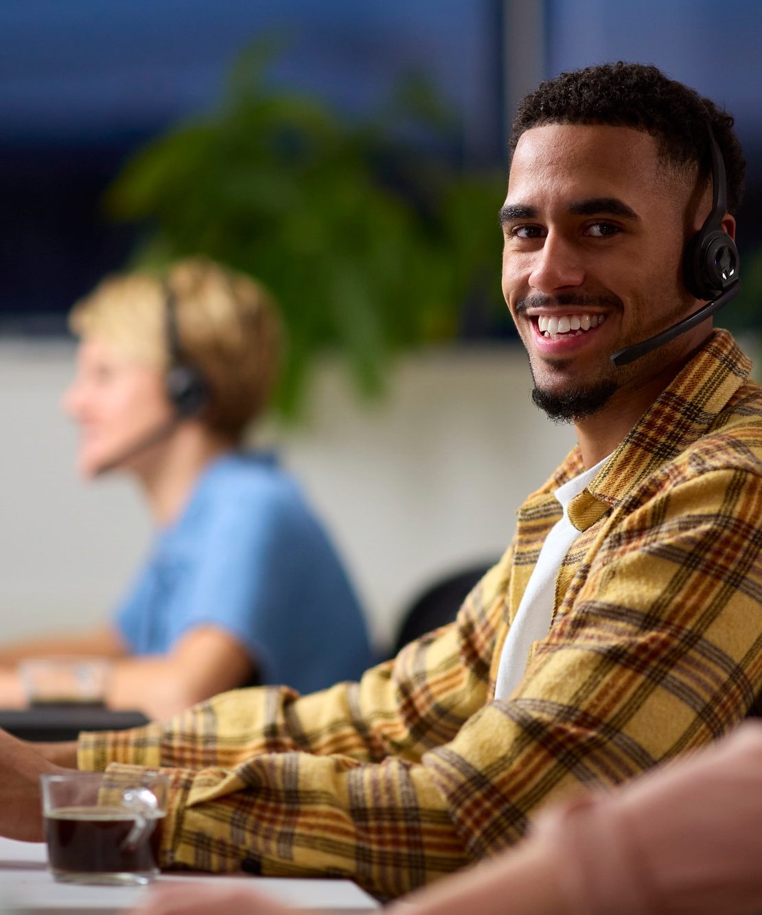 Portrait Of Business Team Wearing Headsets Working Late At Customer Support Centre