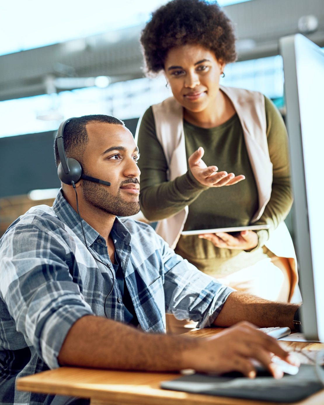 Shot of a young businesswoman assisting her colleague in a call centre